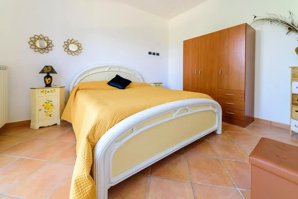 Lemon bedroom: double room at Villa MaLuGio with yellow bedspread, lemon-decorated nightstands and wooden wardrobe, Cilento