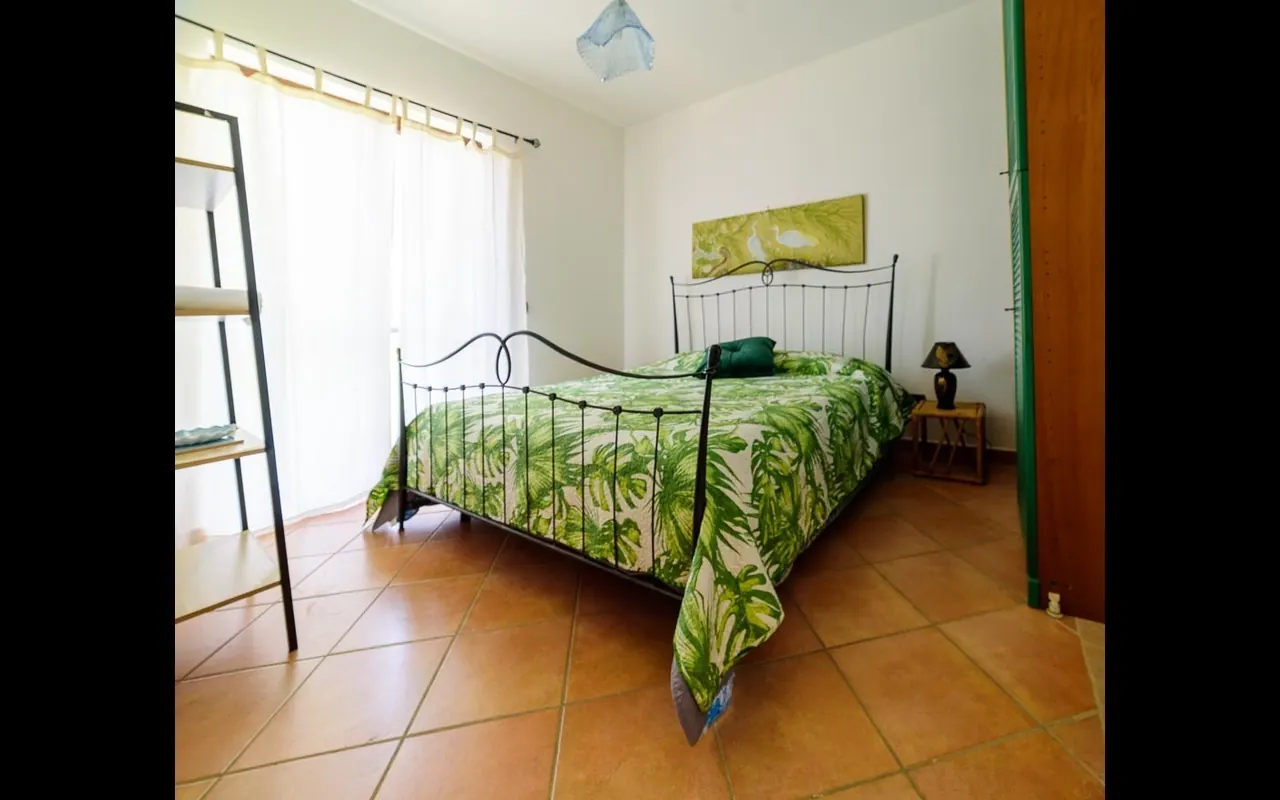 Wrought-iron bedroom: bright double room at Villa MaLuGio with iron bed and white curtains, Casal Velino