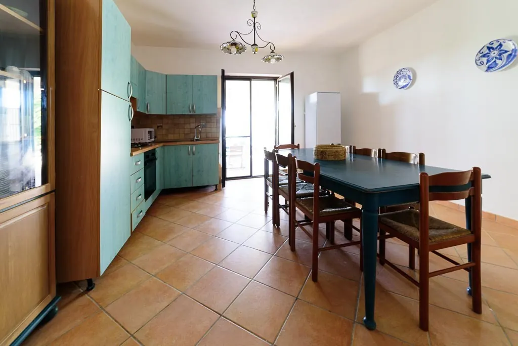 Kitchen and dining room: Villa MaLuGio kitchen with turquoise cabinets, blue table for 8 and terracotta, Casal Velino Cilento