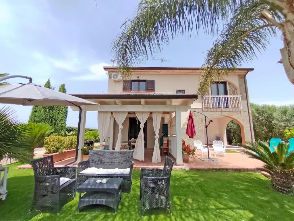 Villa MaLuGio in Casal Velino, Cilento: facade with covered veranda, palms and private garden overlooking the hills