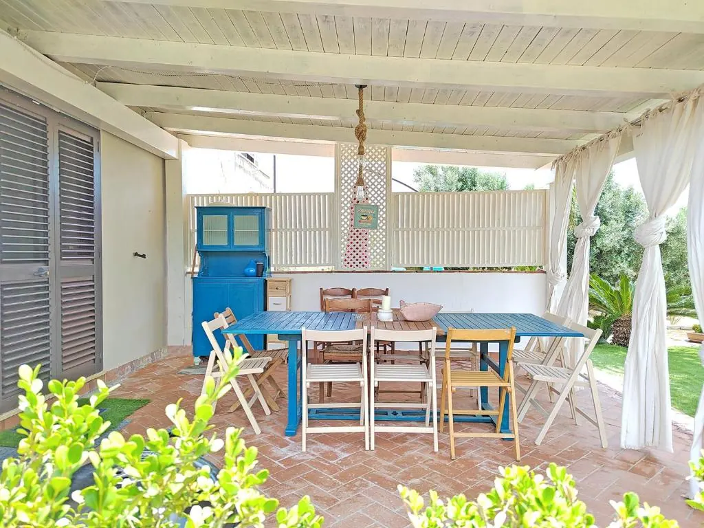 Pergola with blue table: pergola at Villa MaLuGio with blue wooden table and white drapes for outdoor dining, Casal Velino Cilento