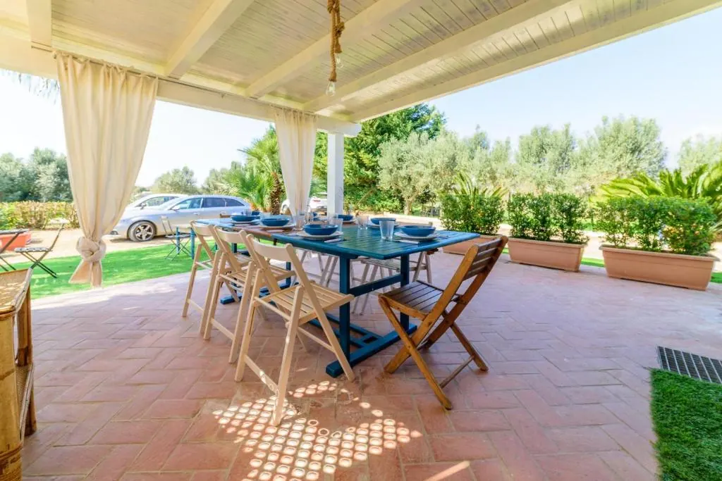 Outdoor dining: outer portico of Villa MaLuGio with blue wooden table set for 12 guests in Cilento